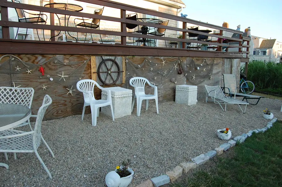 Lower deck with white chairs and sea grass