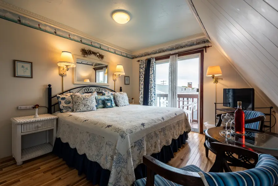 Guest room with sloped ceiling and balcony door