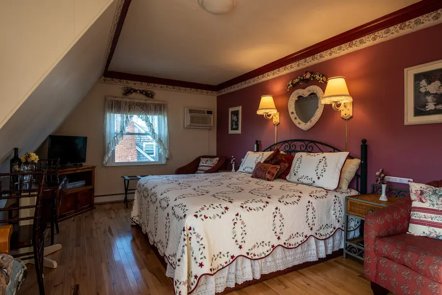 Guest room with a king bed and rose walls