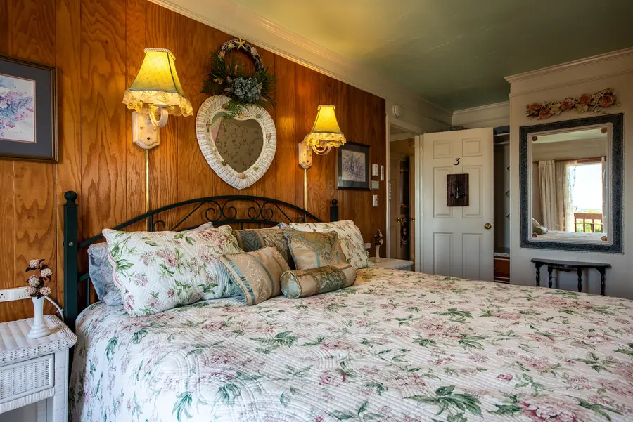 Guest room with floral bedding and wood paneling